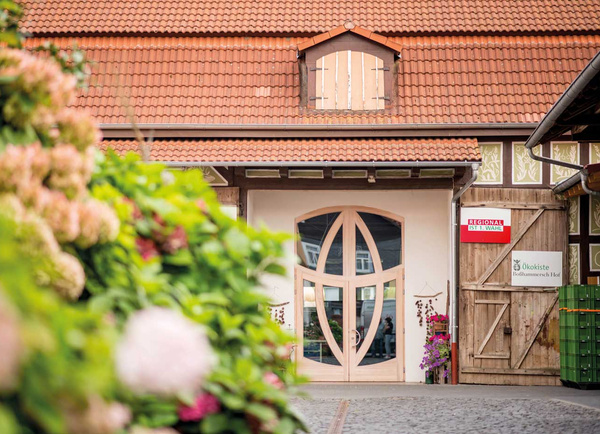 Ein Ökokisten-Fahrer mit Migrationshintergrund überreicht eine Ökokiste an eine Firma in der Region.