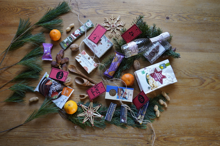 KI generiert: Weihnachtliche Anordnung von Leckereien, Geschenken und Tannenzweigen auf einem Holztisch.