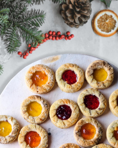 Das Bild zeigt mehrere Personen, die in einer Küche zusammenarbeiten, vermutlich bei einem Kochkurs oder einer Gruppenkochaktivität. Sie tragen Schürzen und sind mit der Zubereitung von Zutaten beschäftigt.