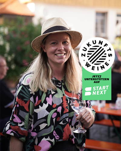 Haneke Schönhals mit Weinglas wirbt für Zukunfstweine