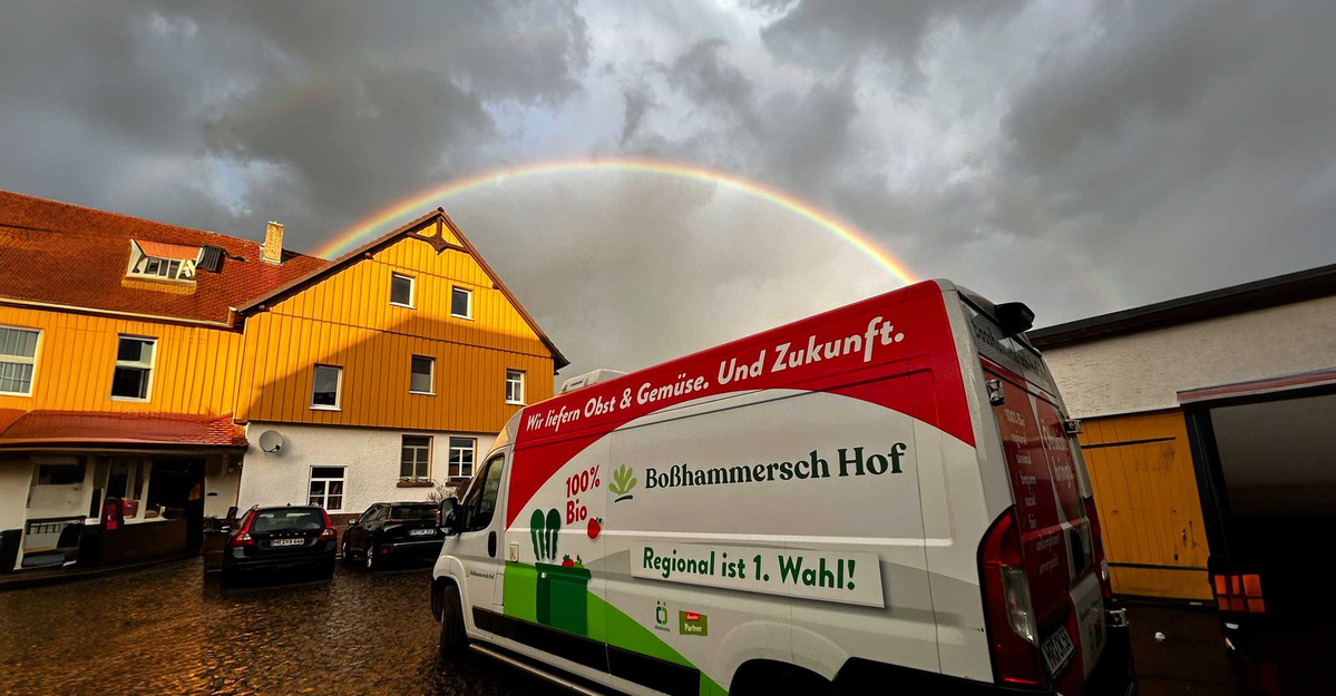 KI generiert: Ein Lieferwagen der Firma "Ökokiste Boßhammersch Hof" steht auf einer verschneiten Landstraße. Der Van wirbt für lokale und biologische Produkte.