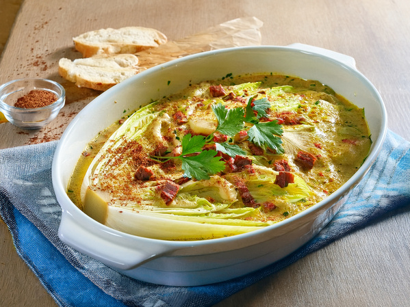 KI generiert: Eine Auflaufform mit überbackenem Chinakohl, garniert mit Kräutern und Wurststücken.