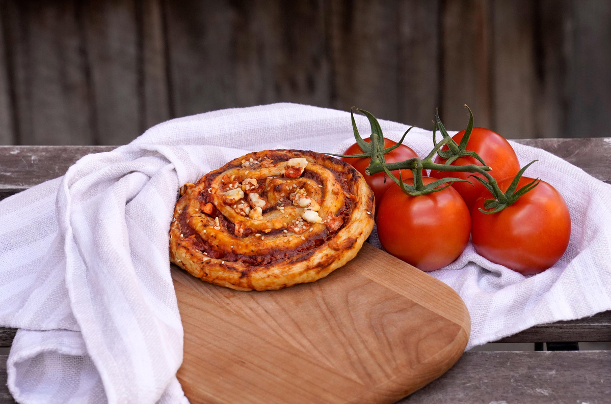 KI generiert: Das Bild zeigt eine Auswahl an Wurzelgemüsen, darunter lila Karotten, Pastinaken und eine Steckrübe, auf einem Holztisch arrangiert.