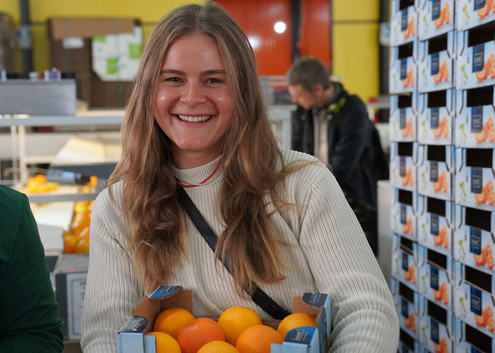 Ruth Firsching mit einer Kiste Orangen in der Hand
