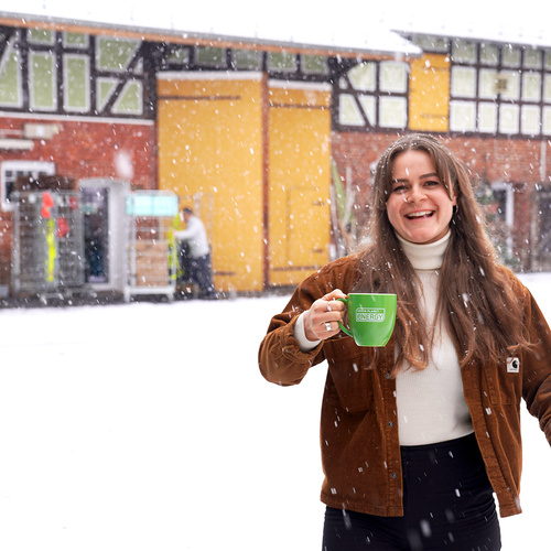 Ruth auf dem verschneiten Hof mit einer Tasse in der Hand