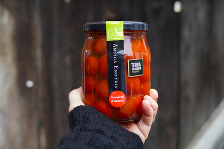 KI generiert: Das Bild zeigt eine Weinflasche mit der Aufschrift "Schönhals Samt & Seide" auf einer hölzernen Treppe, die von einem grauen Stoff umgeben ist. Der Fokus liegt auf der Weinflasche.