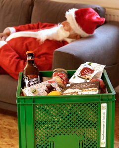 Das Bild zeigt mehrere Personen, die in einer Küche zusammenarbeiten, vermutlich bei einem Kochkurs oder einer Gruppenkochaktivität. Sie tragen Schürzen und sind mit der Zubereitung von Zutaten beschäftigt.