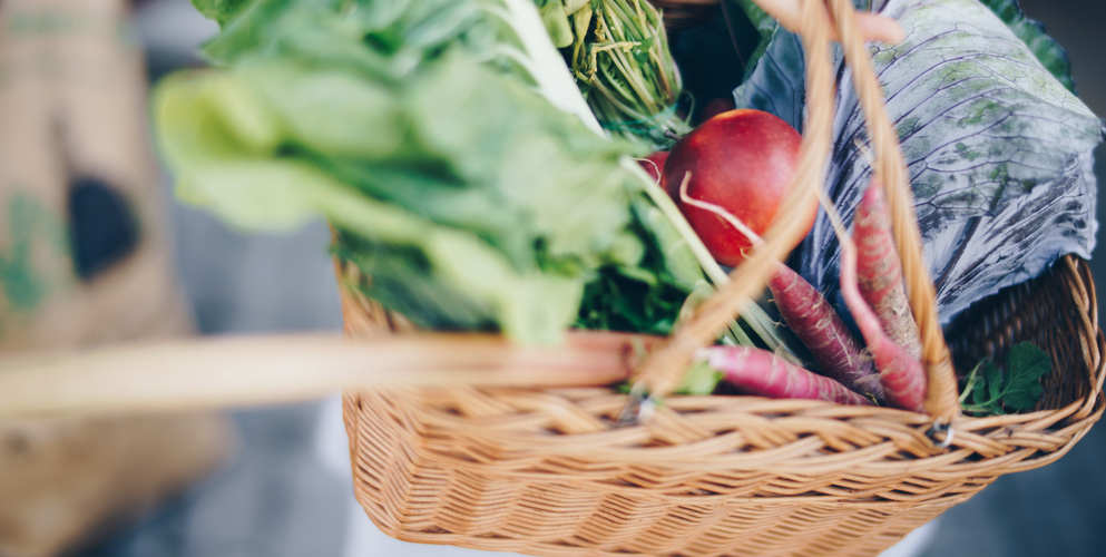 KI generiert: Ein Korb mit frischem Gemüse und Obst, darunter Salat und Möhren.