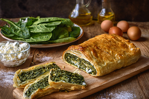 KI generiert: Das Bild zeigt ein Stück Apfelkuchen auf einem Teller, daneben liegt eine Gabel. Der Fokus liegt auf der knusprigen Kruste und der saftigen Füllung des Kuchens.