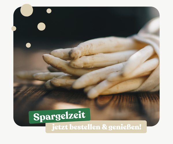 KI generiert: Weiße Spargelstangen auf einem Tisch. Text: "Spargelzeit jetzt bestellen & genießen!"