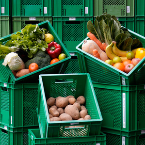 KI generiert: Das Bild zeigt mehrere Personen, die in einer Küche zusammenarbeiten, vermutlich bei einem Kochkurs oder einer Gruppenkochaktivität. Sie tragen Schürzen und sind mit der Zubereitung von Zutaten beschäftigt.