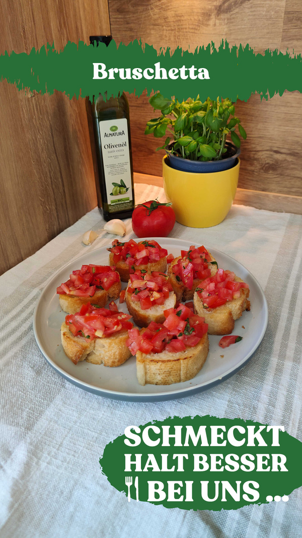Teller mit Bruschetta, im Hintergrund Olivenöl und Basilikum