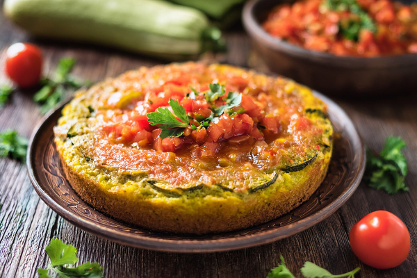 KI generiert: Das Bild zeigt ein Stück Apfelkuchen auf einem Teller, daneben liegt eine Gabel. Der Fokus liegt auf der knusprigen Kruste und der saftigen Füllung des Kuchens.