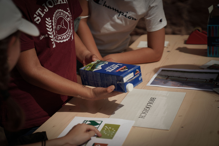 Kind hält Milchtüte in der Hand