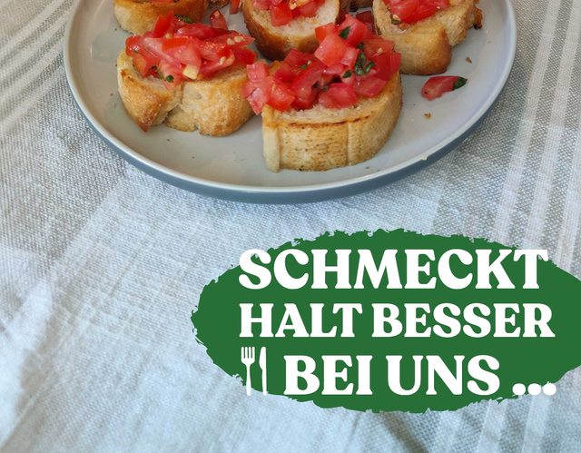 Teller mit Bruschetta, im Hintergrund eine Flasche Olivenöl und Basilikumpflanze