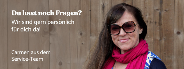 KI generiert: Eine Frau vor Holzwand, Text: "Du hast noch Fragen? Wir sind gern persönlich für dich da! Carmen aus dem Service-Team".