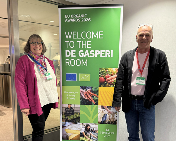 KI-generierte Beschreibung: Zwei Personen vor einem EU-Organic-Awards-2026-Schild im De Gasperi Room.