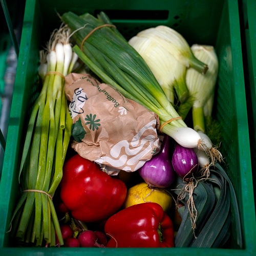 Gepackte Obst- und Gemüsekiste mit frischem Knoblauch mit Wackelaugen