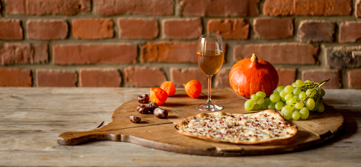 KI generiert: Das Bild zeigt eine Auswahl an Wurzelgemüsen, darunter lila Karotten, Pastinaken und eine Steckrübe, auf einem Holztisch arrangiert.
